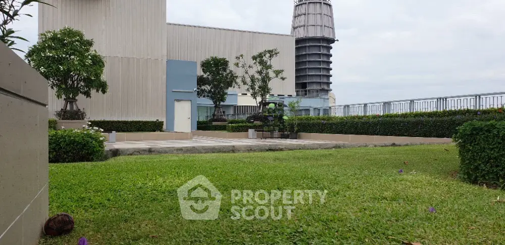 Spacious rooftop garden with lush greenery and modern architecture, perfect for relaxation and leisure.