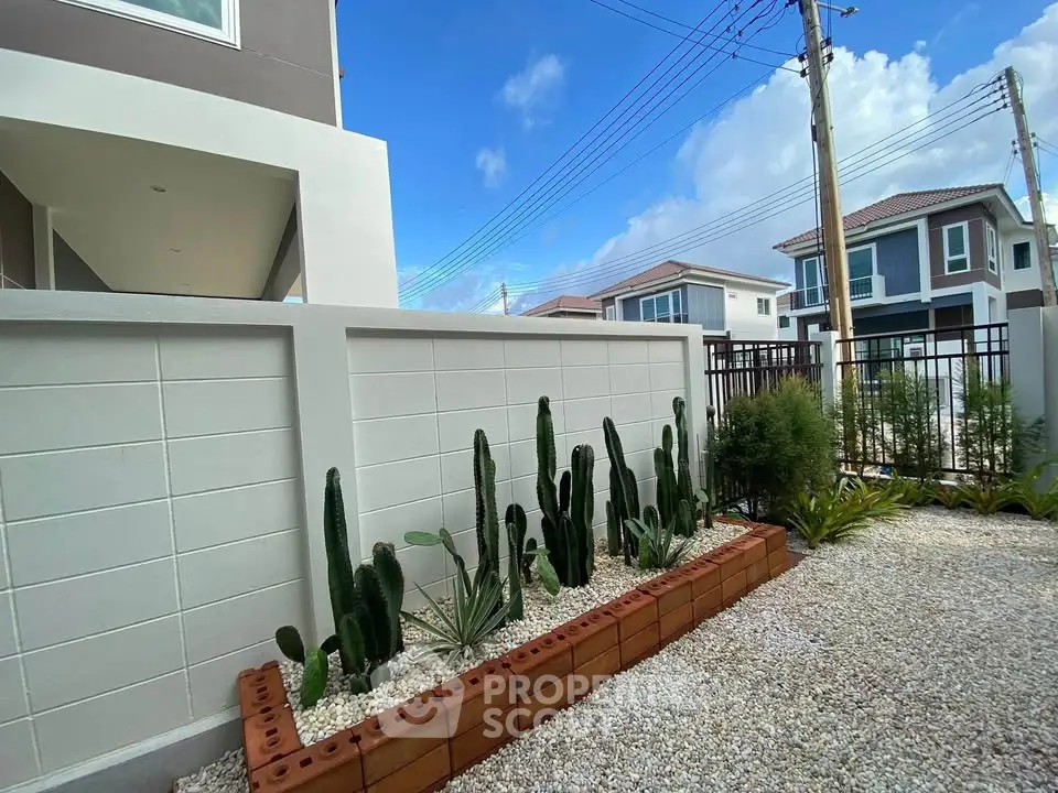 Modern residential exterior with cactus garden and clear blue sky