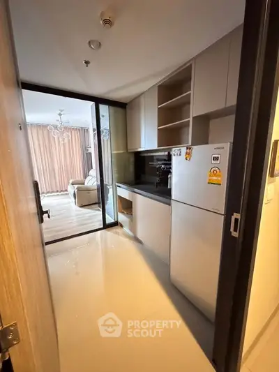 Modern kitchen with sleek design and open layout leading to a bright living room.