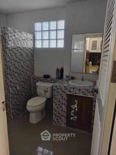 Charming bathroom with modern tile design and natural light, perfect for a cozy home.