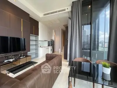 Modern living room with open kitchen, featuring sleek furniture and large windows with city view.
