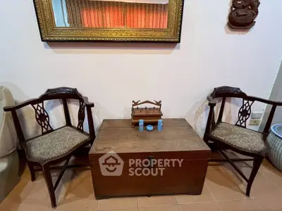 Charming vintage living room setup with elegant wooden chairs and a classic chest table.