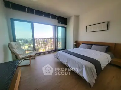 Spacious bedroom with large window offering stunning city views, modern furnishings, and elegant decor.
