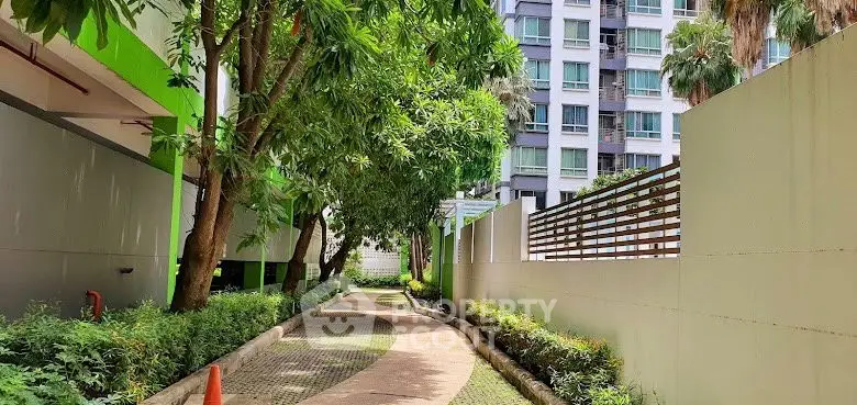 Serene garden pathway in modern residential complex with lush greenery.