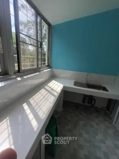 Bright kitchen with blue accent wall and large windows