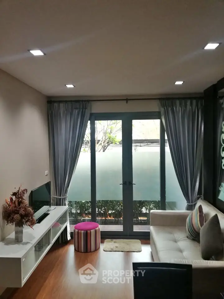 Cozy living room with modern decor and large window for natural light.