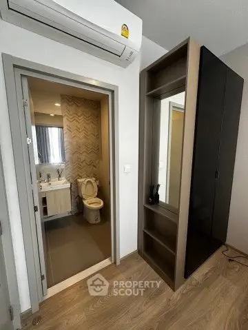 Modern apartment interior with bathroom and wardrobe, featuring sleek design and air conditioning.