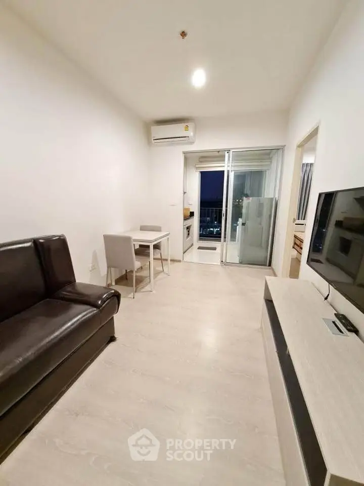 Modern living room with sleek furniture and balcony access