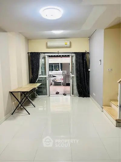 Spacious living room with modern decor and balcony access
