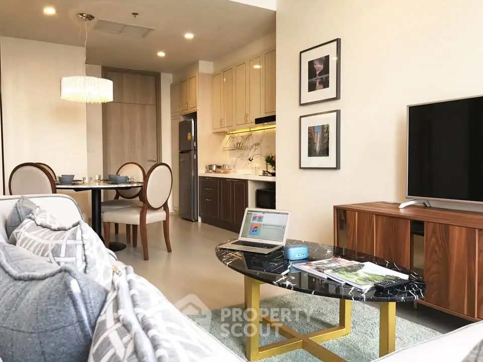 Modern living room with open kitchen, stylish decor, and cozy dining area in a contemporary apartment.