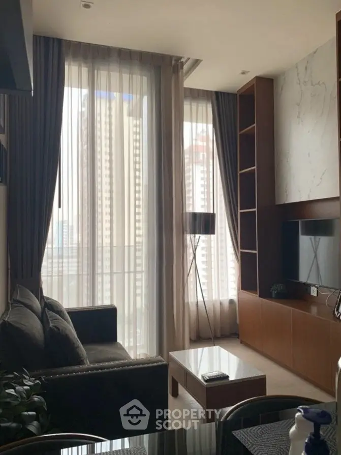 Modern living room with floor-to-ceiling windows and stylish decor in urban apartment.