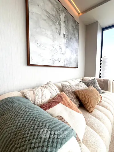 Luxurious living room with plush sofa and modern art, perfect for stylish relaxation.