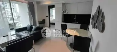 Modern living room with sleek furniture and large windows offering city views.