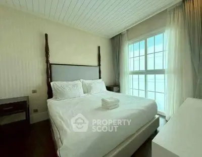 Elegant bedroom with large window and stylish decor, perfect for a serene retreat.