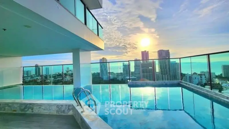Stunning rooftop pool with panoramic city and ocean views at sunset.