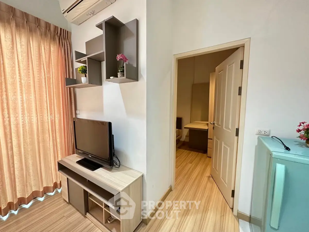 Modern living room with TV and stylish shelving in cozy apartment