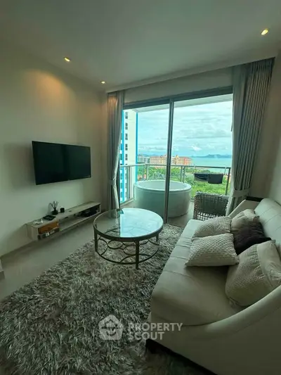 Luxurious living room with stunning ocean view and cozy balcony seating.