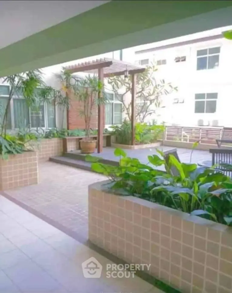 Modern apartment building with lush garden terrace and stylish design.
