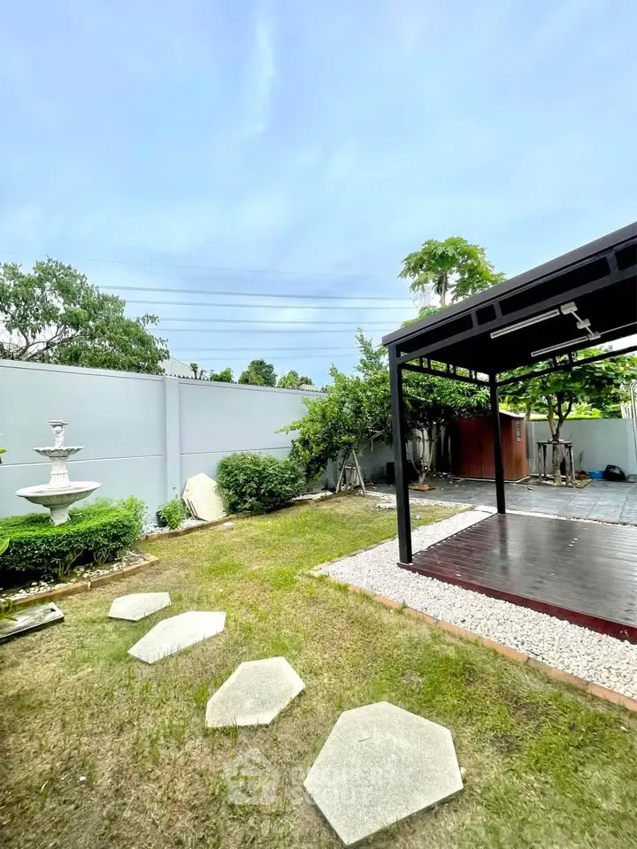 Spacious garden with modern gazebo and stepping stones in a serene backyard setting.