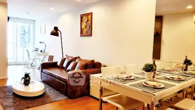 Modern living room with stylish decor and dining area, featuring cozy seating and elegant table setting.