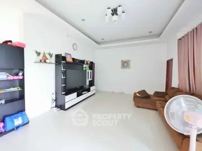 Spacious living room with modern entertainment center and cozy seating area.