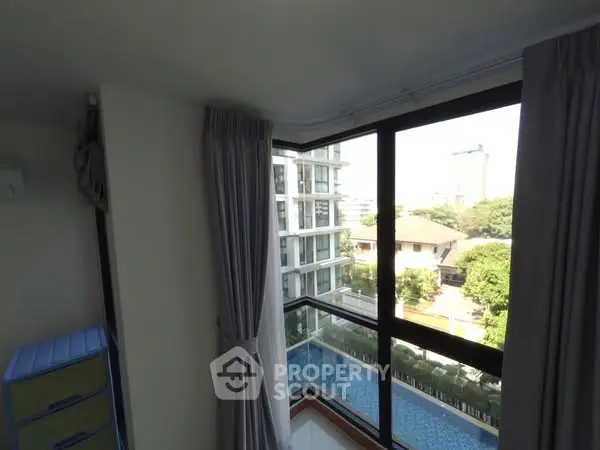 Bright corner unit with large windows offering a stunning pool view in a modern apartment complex.