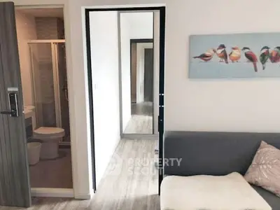 Modern apartment interior with cozy living room and bathroom view.