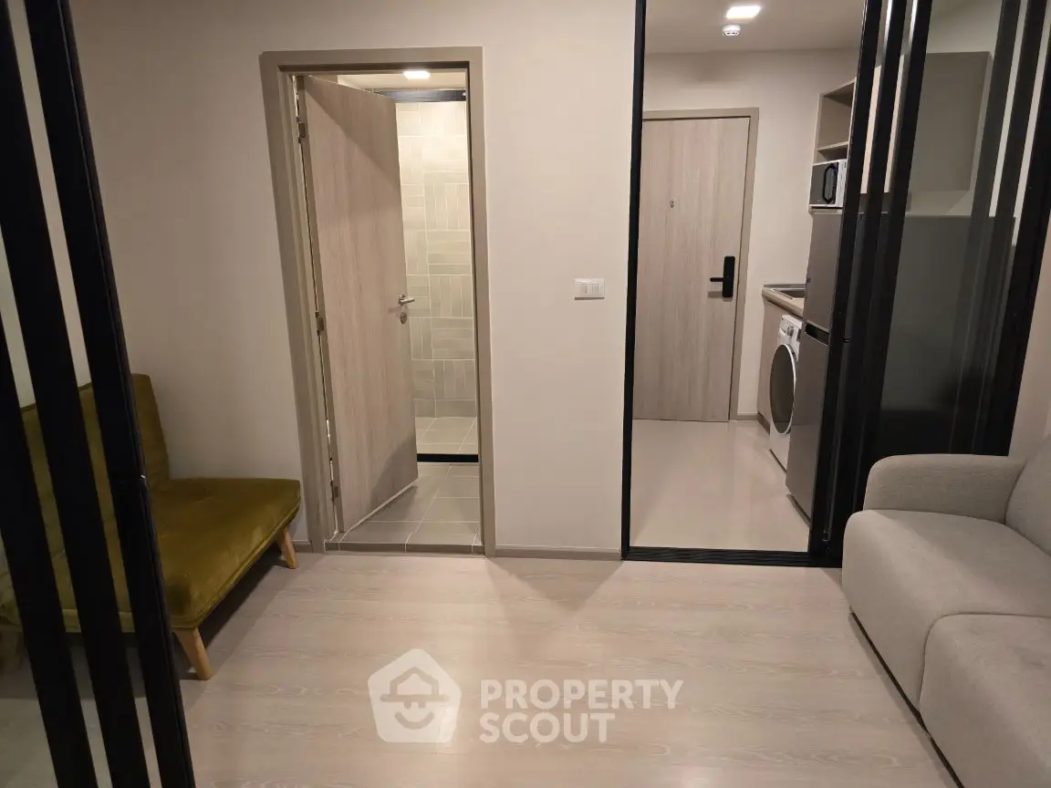 Modern apartment interior with open layout, featuring a cozy living area and compact kitchen.