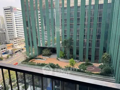 Stunning urban view from a high-rise balcony overlooking modern architecture and cityscape.