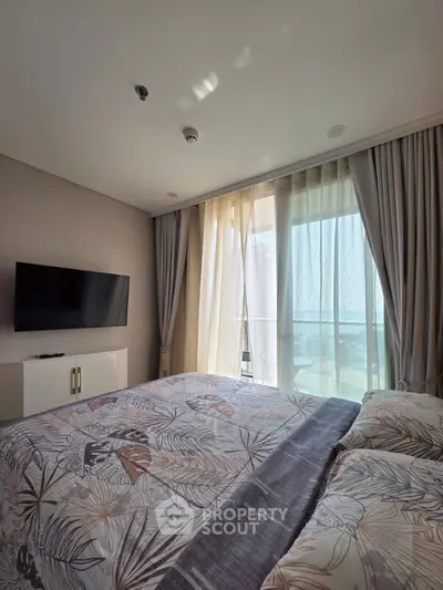 Cozy bedroom with large window and modern decor, perfect for relaxation.