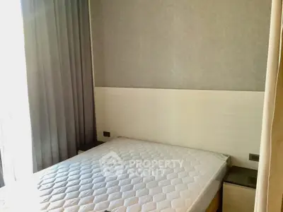 Cozy bedroom with natural light and modern decor, featuring a comfortable mattress and elegant curtains.