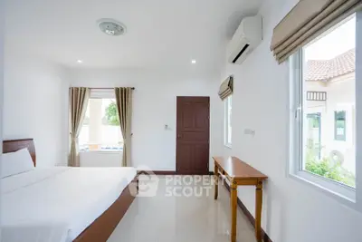 Bright and airy bedroom with large windows and minimalist decor in modern home.