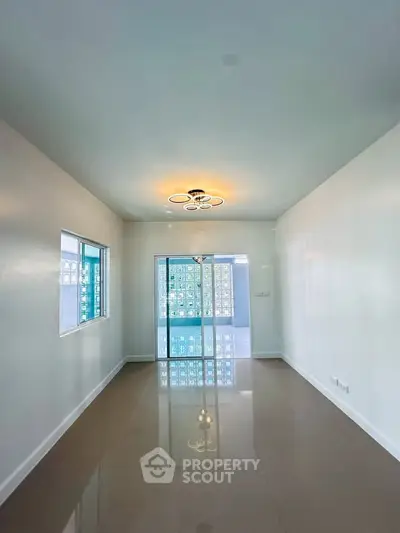 Spacious modern living room with elegant lighting and glossy tiled floors