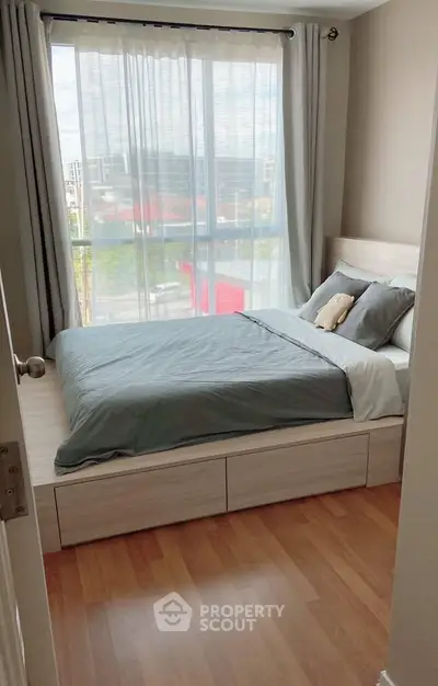 Cozy bedroom with large window and modern decor in a bright apartment.