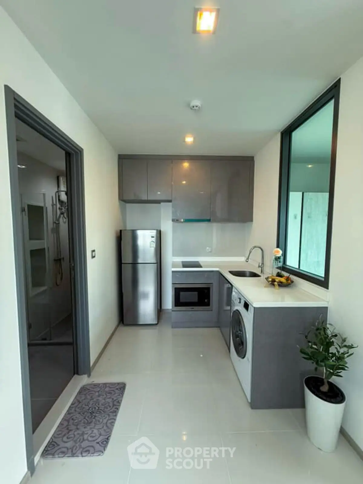 Modern kitchen with sleek appliances and a washing machine in a compact layout.
