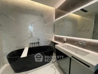 Luxurious modern bathroom with sleek black bathtub and elegant marble finishes.