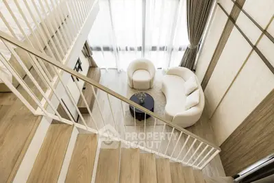 Modern loft with stylish staircase and cozy living area, featuring elegant furniture and large windows.