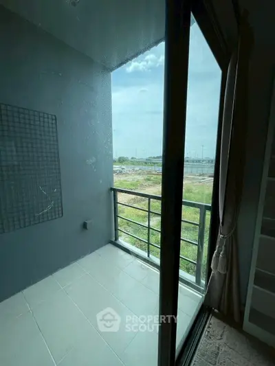 Modern balcony with glass door offering expansive views of open landscape, perfect for relaxation.