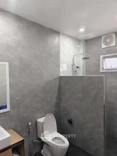 Modern bathroom with sleek gray tiles and contemporary fixtures.