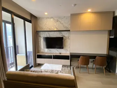 Modern living room with marble accent wall and balcony view in luxury apartment.