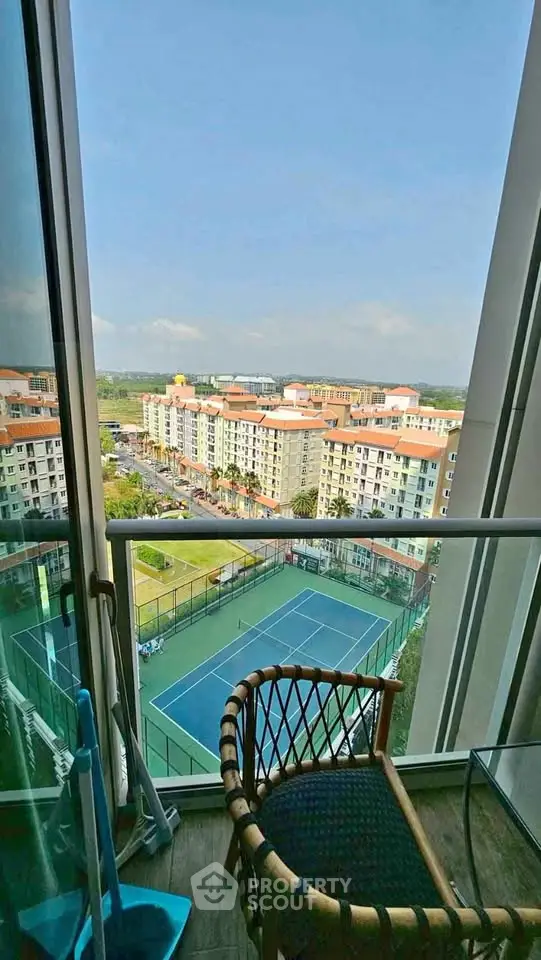 Stunning high-rise balcony view overlooking tennis courts and cityscape, perfect for urban living enthusiasts.