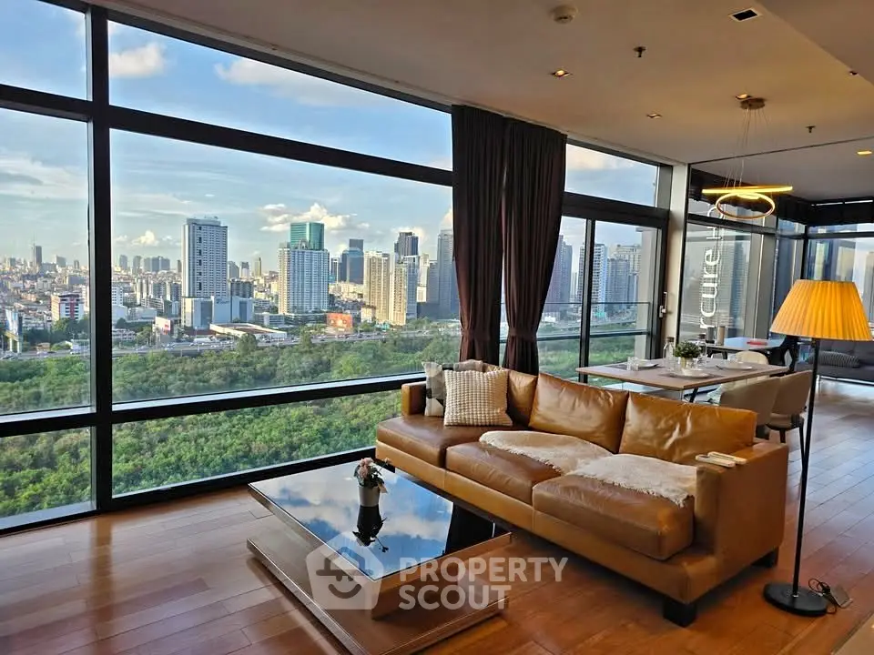 Luxurious living room with stunning city view and modern decor in high-rise apartment.