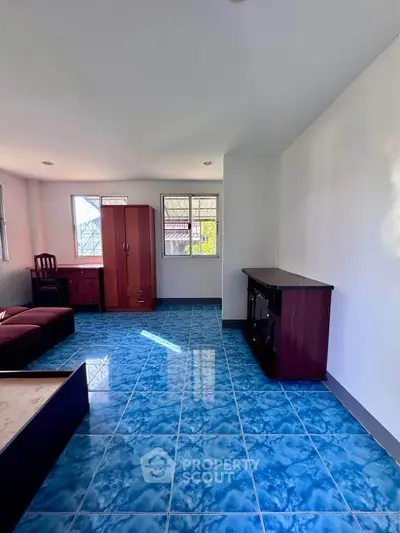 Spacious living room with blue tiled floor and natural light