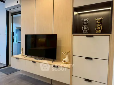 Modern living room with stylish cabinetry and TV setup, featuring elegant decor and sleek design.