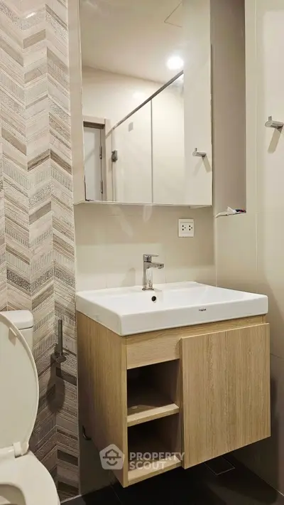 Modern bathroom with sleek vanity and large mirror in contemporary apartment.