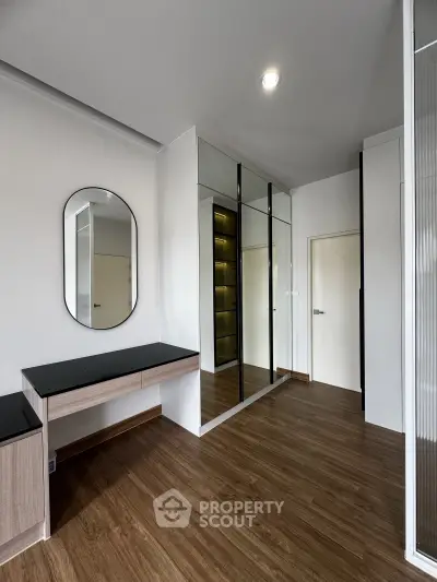 Modern bedroom with sleek mirrored wardrobe and elegant vanity desk
