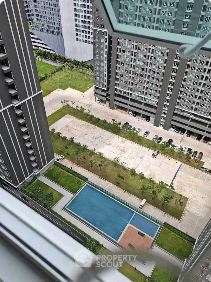 High-rise apartment view with pool and parking area, showcasing modern urban living.