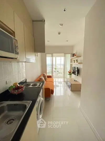 Modern compact apartment with open kitchen and cozy living area, featuring sleek design and natural light.