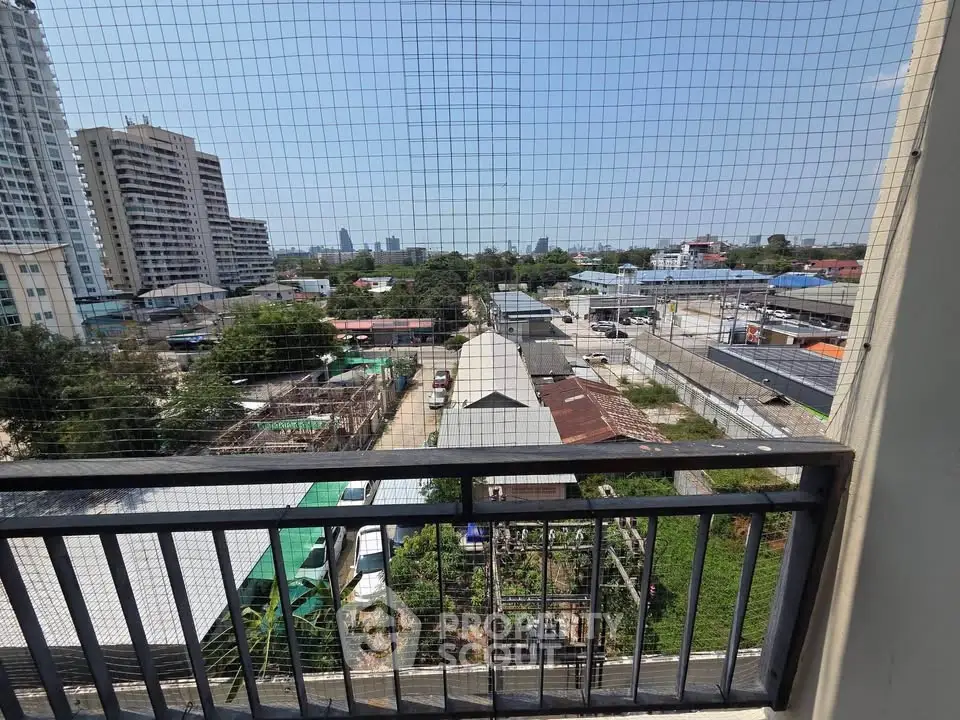 Urban balcony view with cityscape and greenery, ideal for modern living.