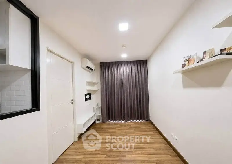 Modern minimalist room with wooden flooring and wall-mounted shelves, ideal for versatile living space.